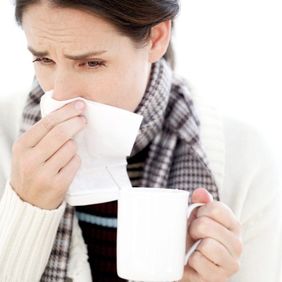 Woman Holding a Mug with a Handkerchief to Her Nose